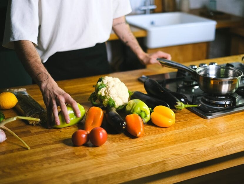 ragazzo che ha sul tagliere le verdure da cucinare