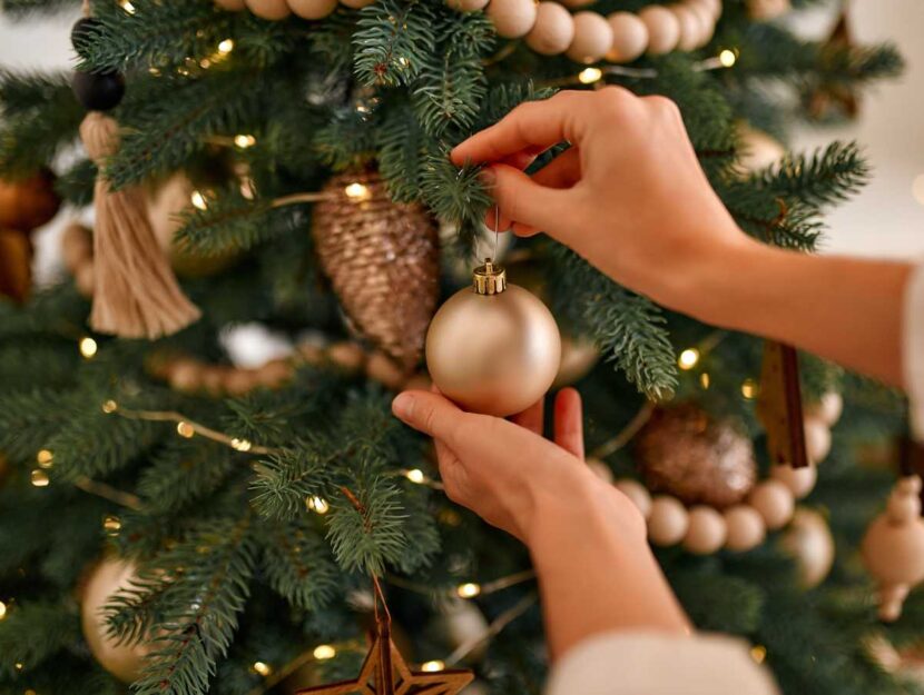 Una donna addobba l'albero di Natale