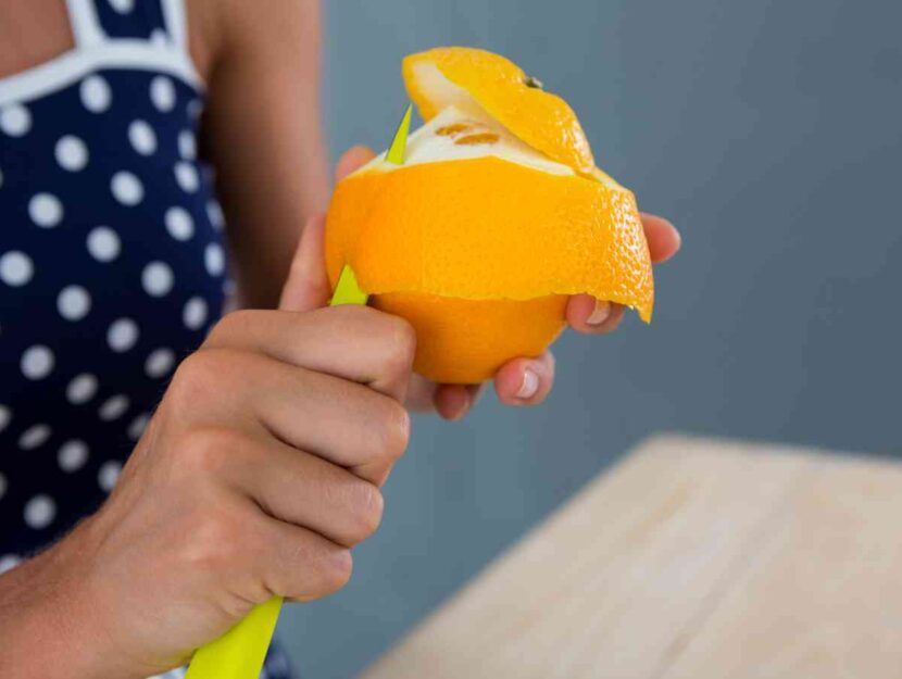 Una donna sbuccia un'arancia