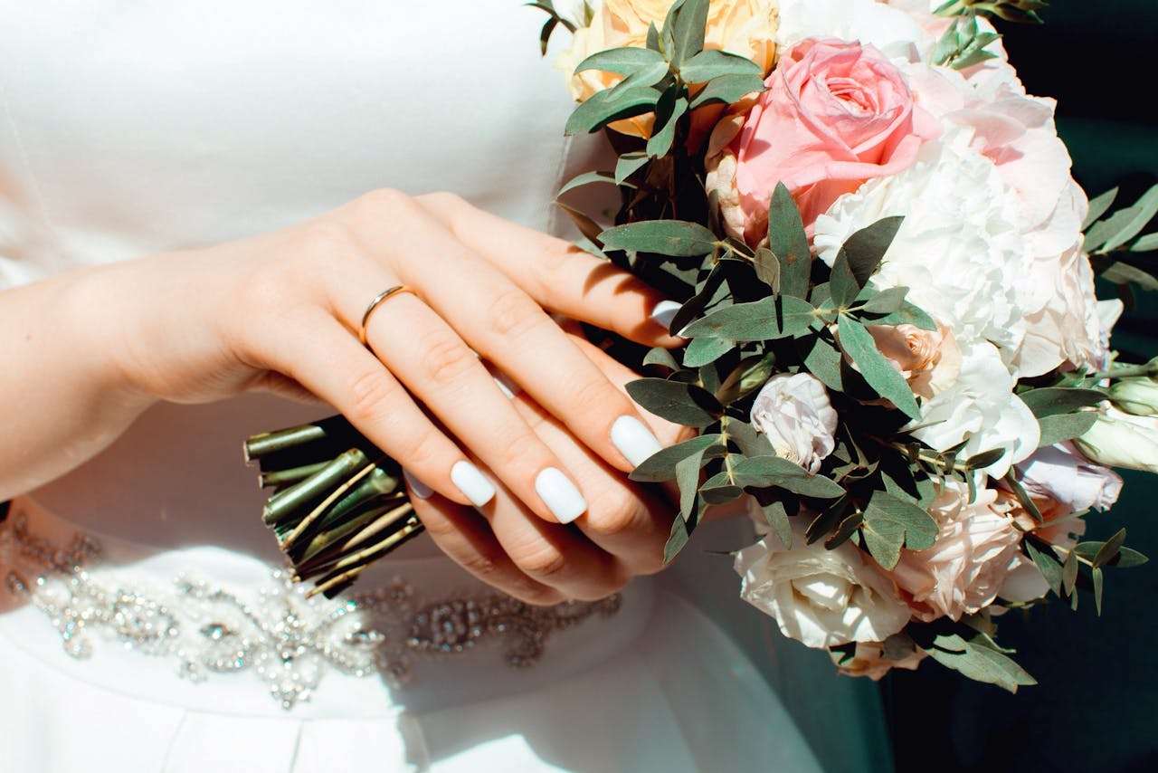 manicure di sposa con bouquet in mano