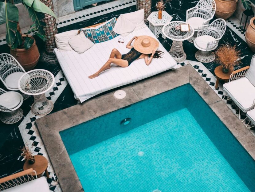 ragazza sdraiata a bordo piscina in un riad in Marocco