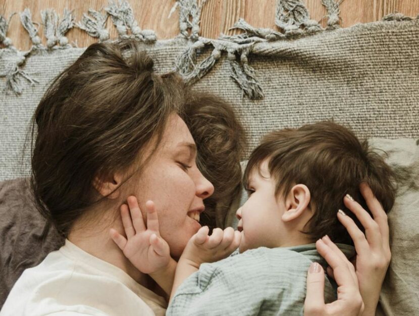 mamma e figlio si abbracciano per terra sul tappeto