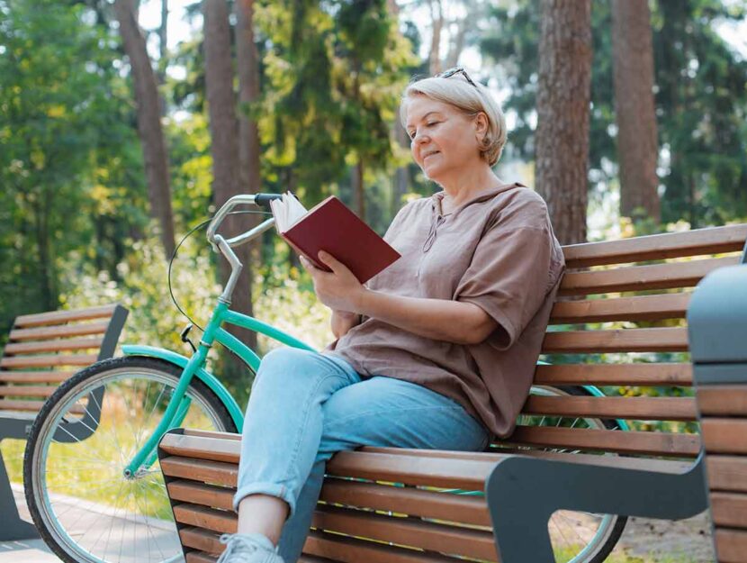 Donna al parco legge un libro