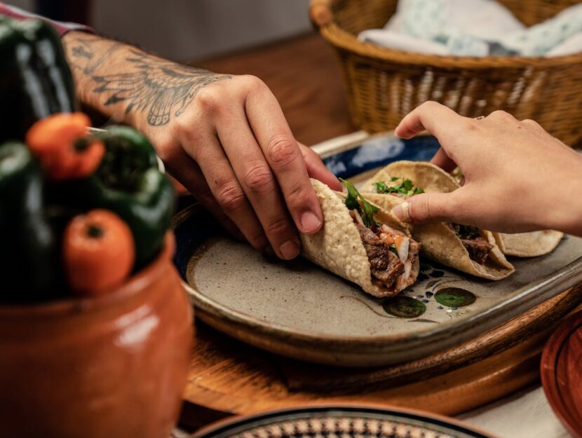 mani di persone che afferrano delle piadine farcite sul tavolo