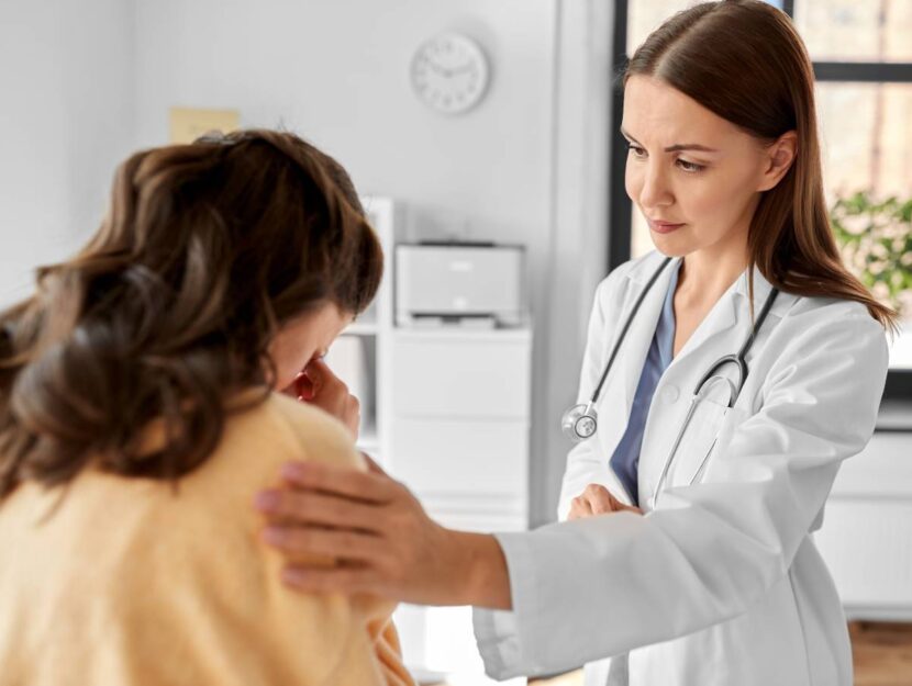 Un medico consola una paziente