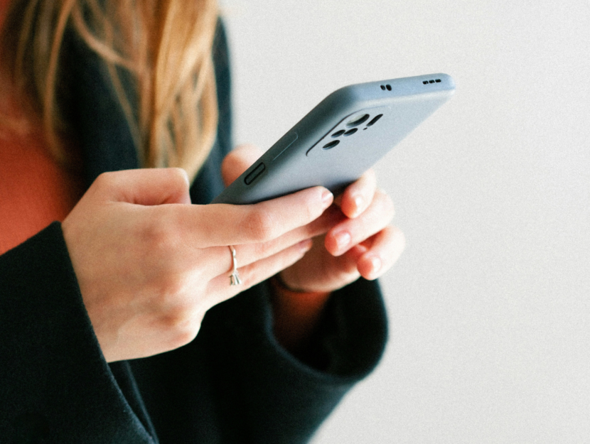 Ragazza che passa il tempo navigando online con smartphone in mano