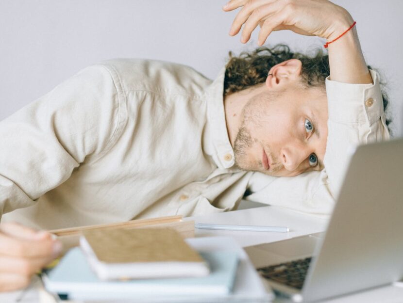 ragazzo accasciato e stanco davanti al computer