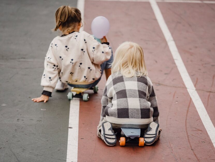 due bambini di spalle si allenano con lo skate