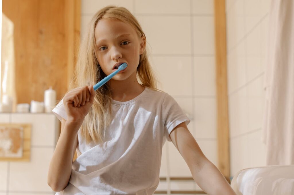 ragazzina si lava i denti in bagno