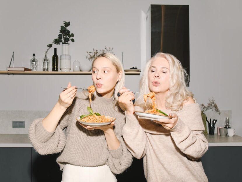 mamma e figlia mangiano un piatto di spaghetti