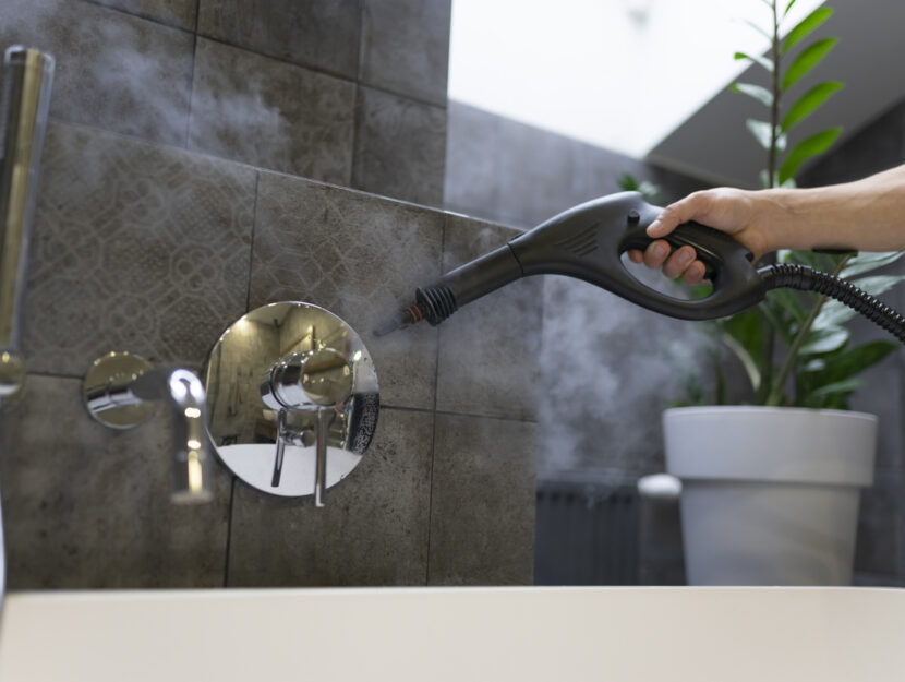 ragazza sta pulendo con un pulitore a vapore il bagno