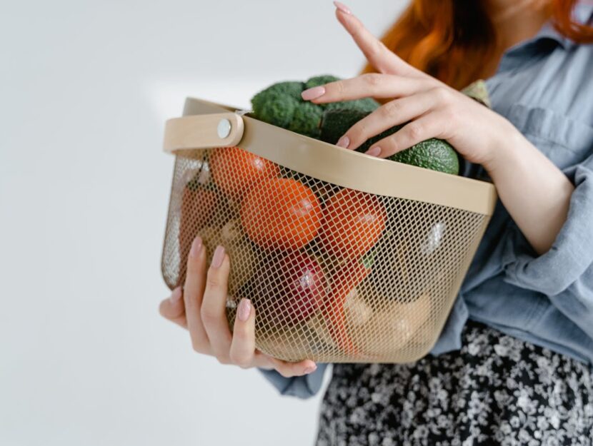 ragazza con cestello pieno di frutta e verdura