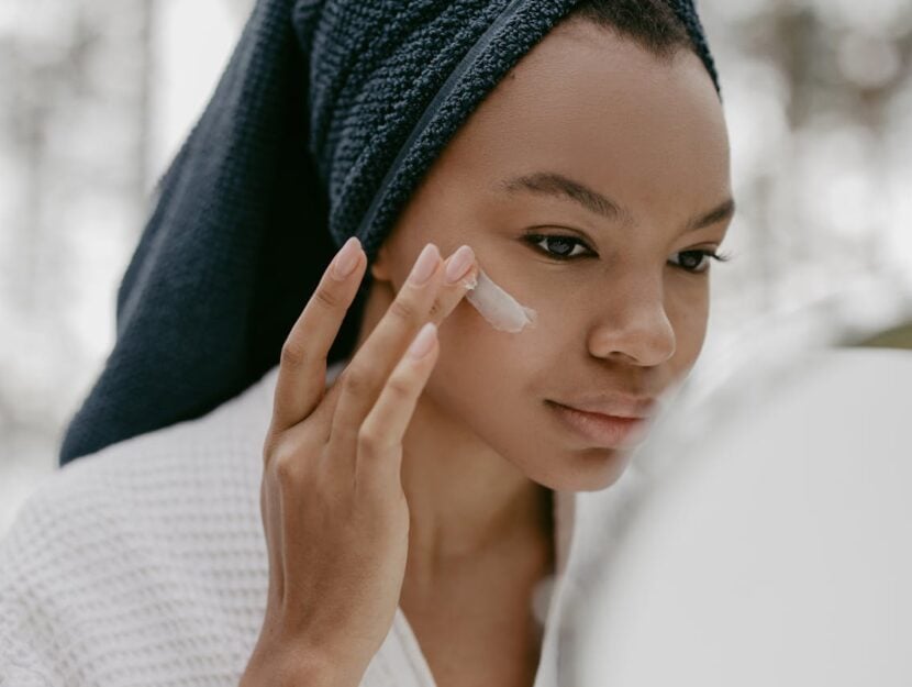 ragazza che si spalma la crema sul viso