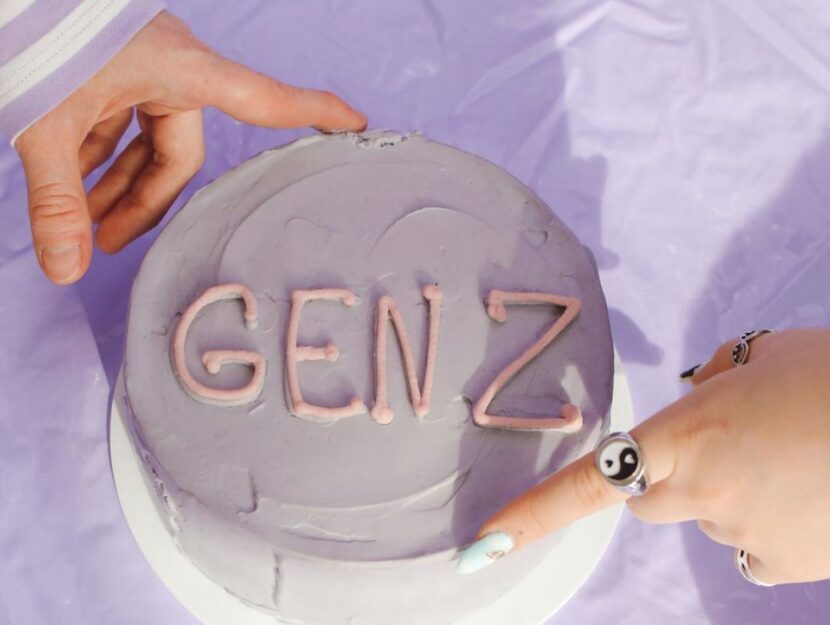 torta con la scritta Gen z e dita che prendono la crema