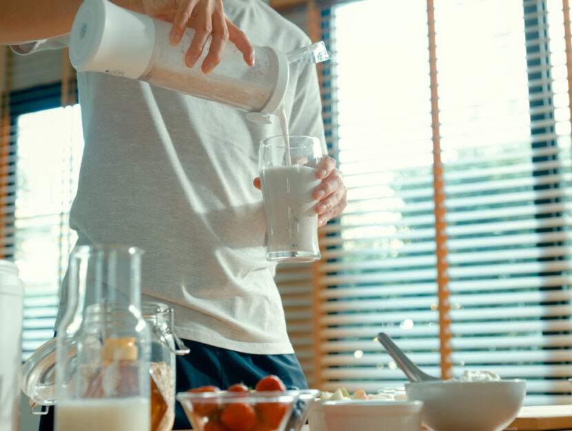 un ragazzo in cucina versa un frullato per la colazione