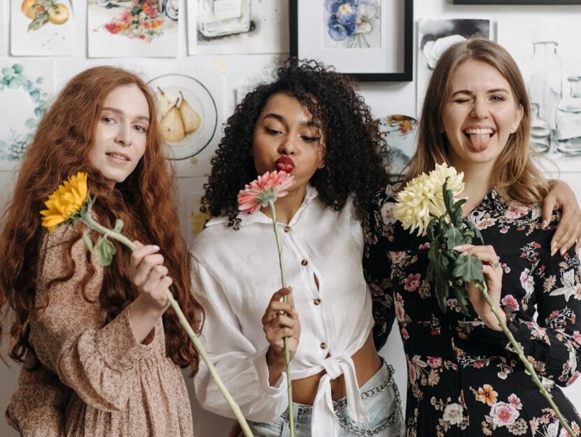 amiche di età diverse con in mano un fiore