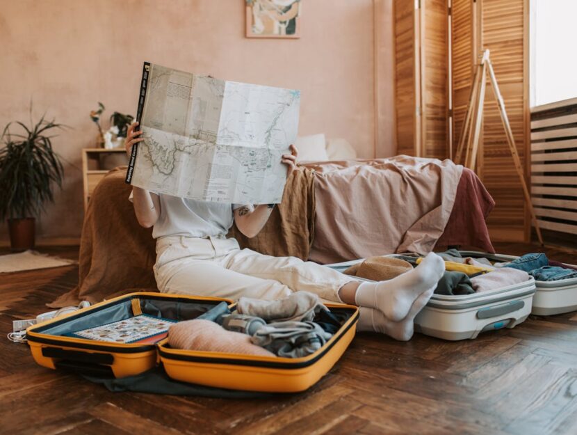 ragazza sta guardando una mappa mentre preparar la valigia per il viaggio