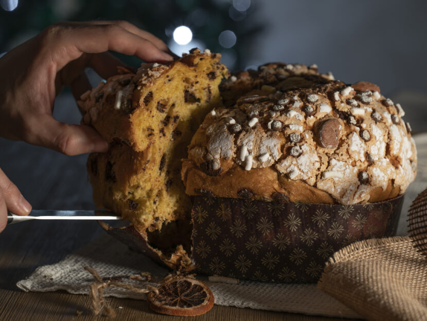 persona sta tagliando fetta di panettone