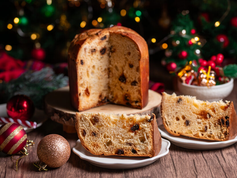 panettone su tagliere e fette di panettone in primo piano