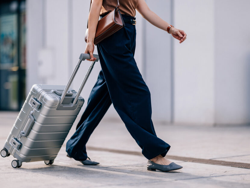 ragazza con valigia cammina in città