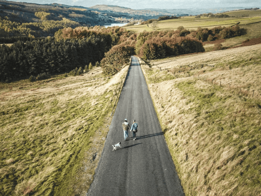 Coppia con cane mentre passeggiano in campagna