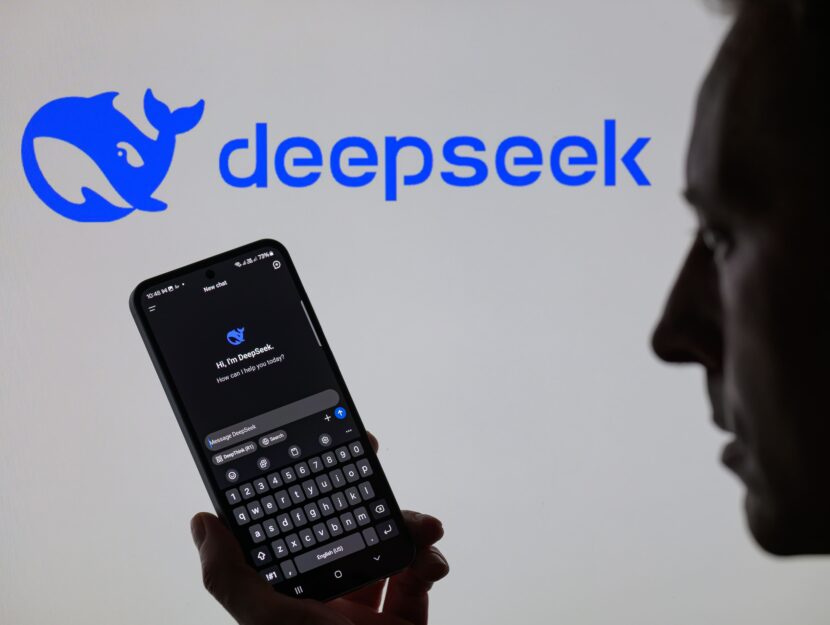 una persona ha in mano un telefono con aperto deepseek