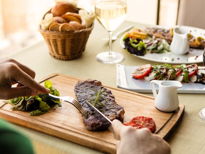 un uomo mangia una bistecca di carne rossa