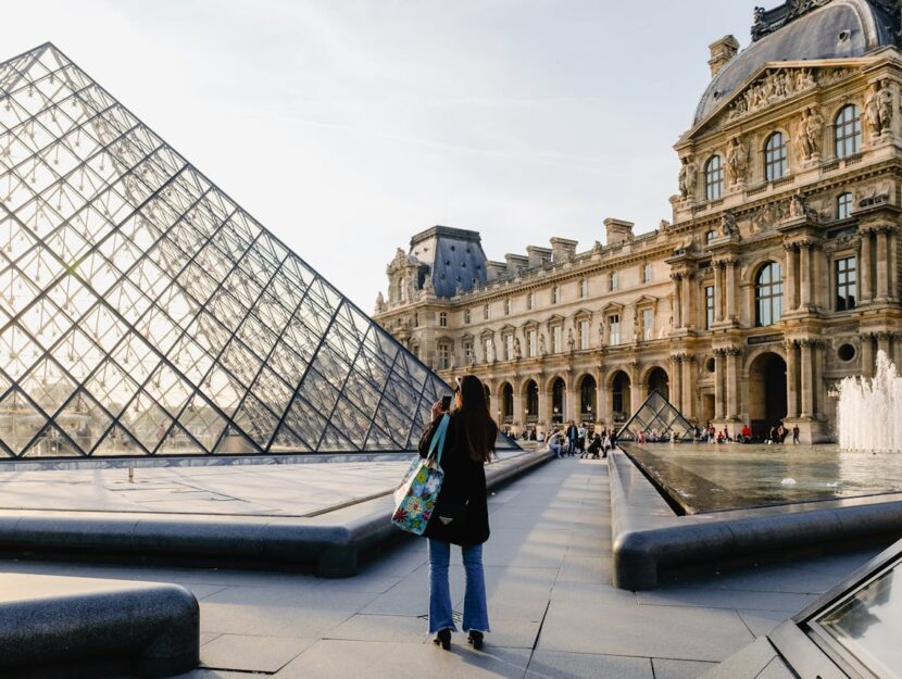 ragazza che fotografa il museo del Louvre