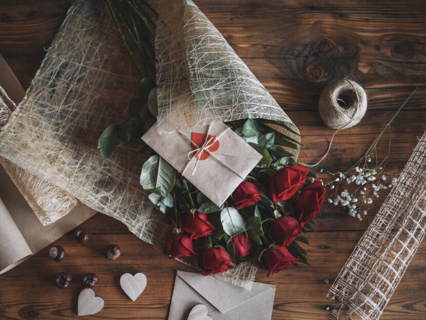 mazzo di rose rosse con cioccolatini sul tavolo