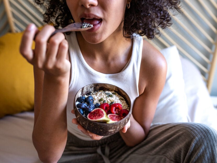 ragazza che mangia porridge con frutta