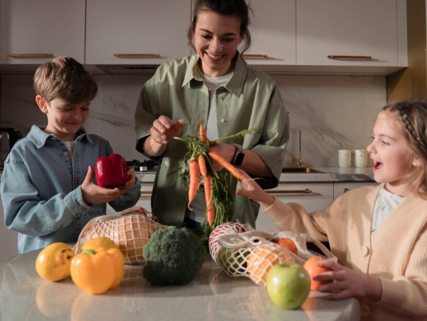 mamma con figli che guardano le verdure appena comprate