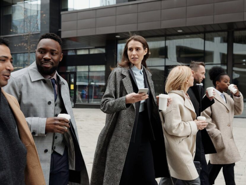 lavoratori in eleganti cappotti con caffè d'asporto