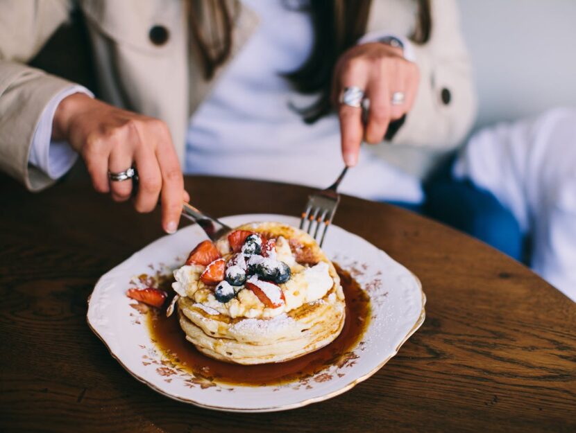 ragazza sta tagliando pancakes