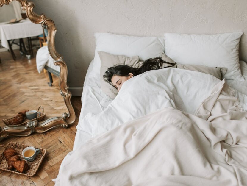 ragazza dorme nel letto sotto il piumone