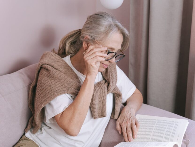 signora in pensione che legge un libro in poltrona