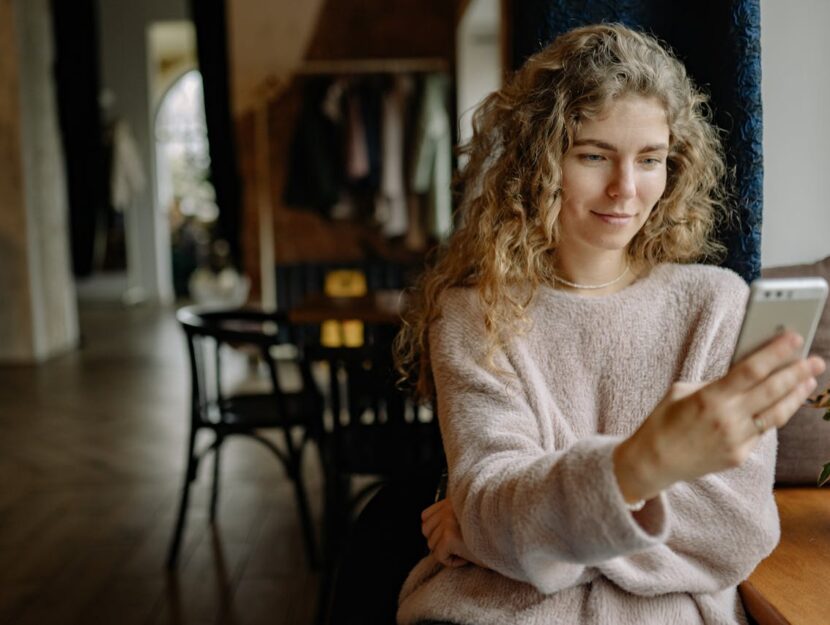 ragazza che guarda il telefono al bar